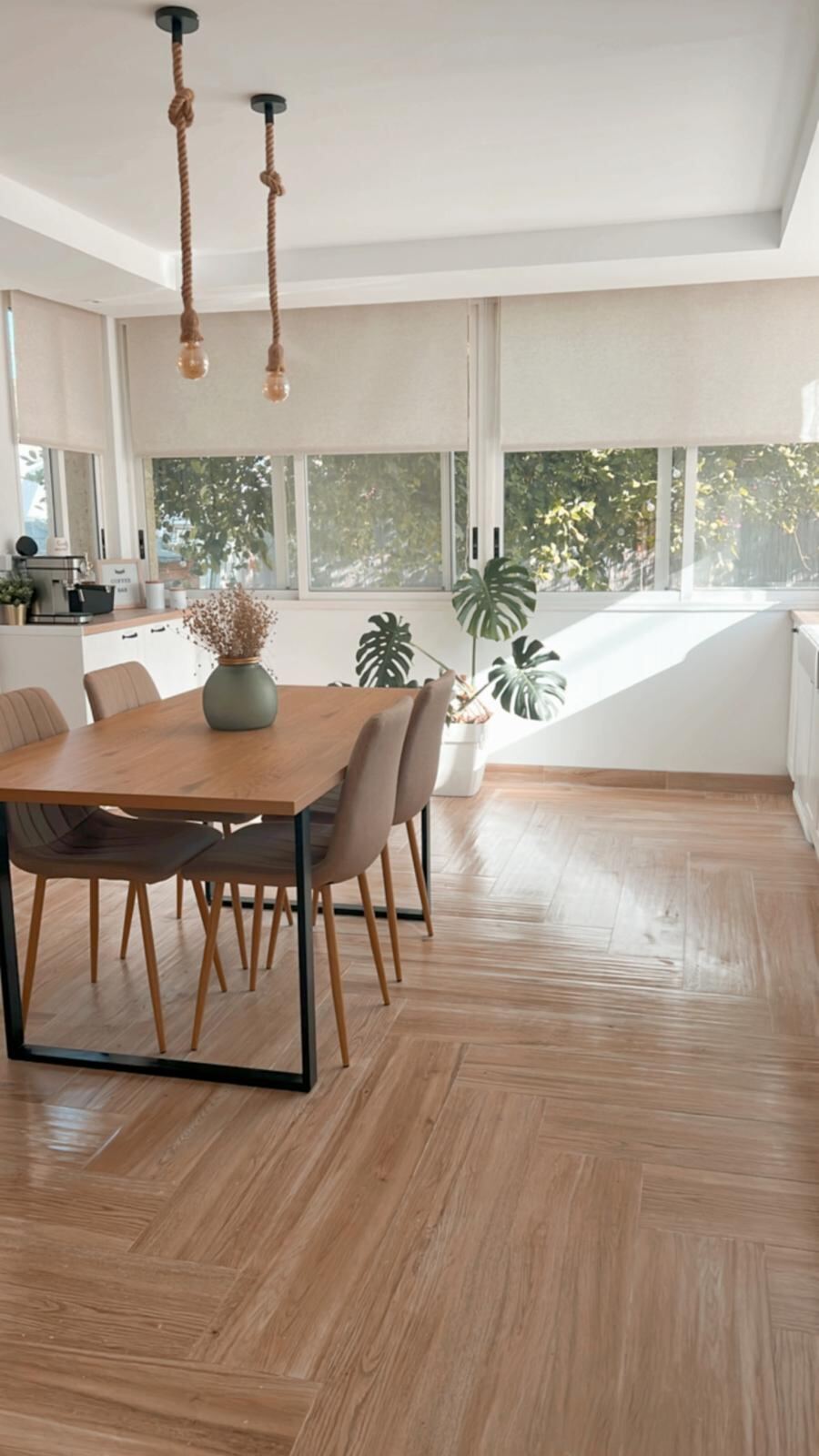 Cocina en L reformada, luz natural y mobiliario en blanco