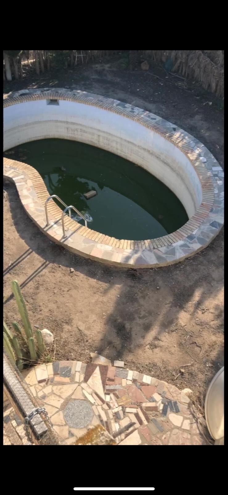 Piscina antes de la reforma, sin acabados ni césped