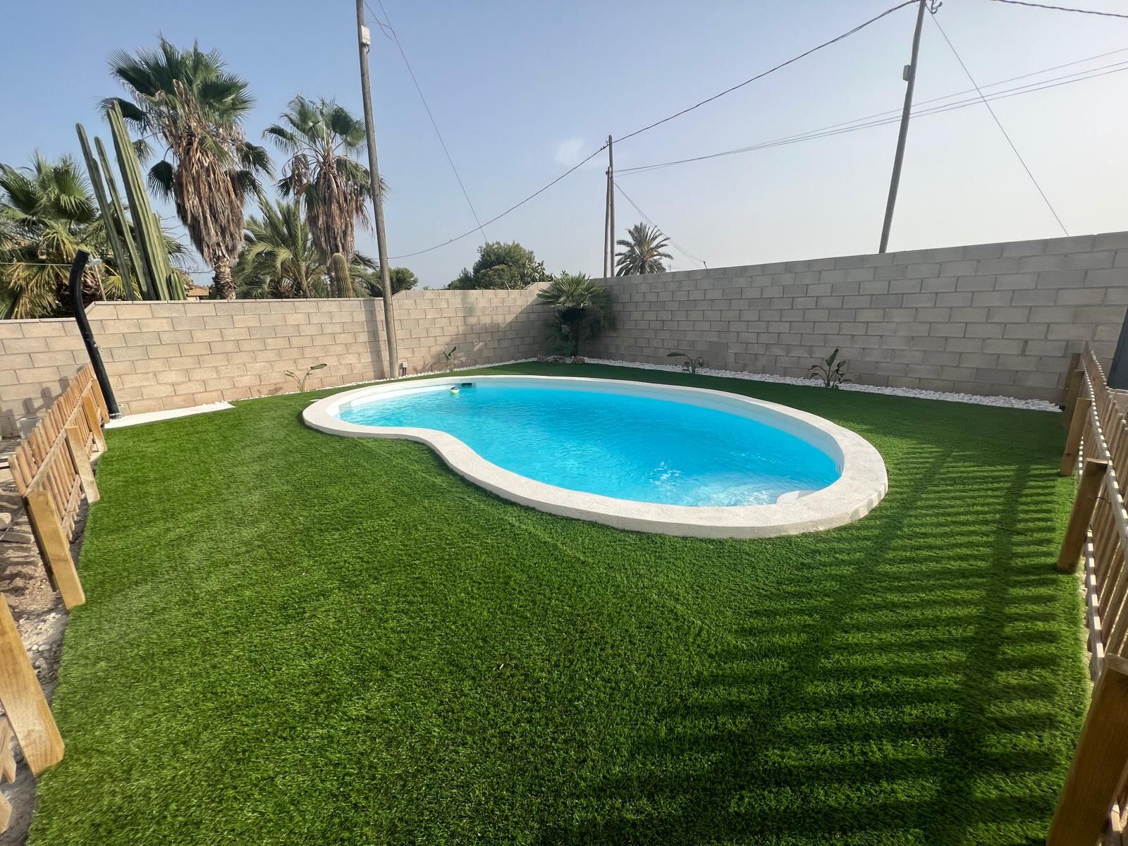 Piscina de obra terminada con césped artificial en San Juan de Alicante